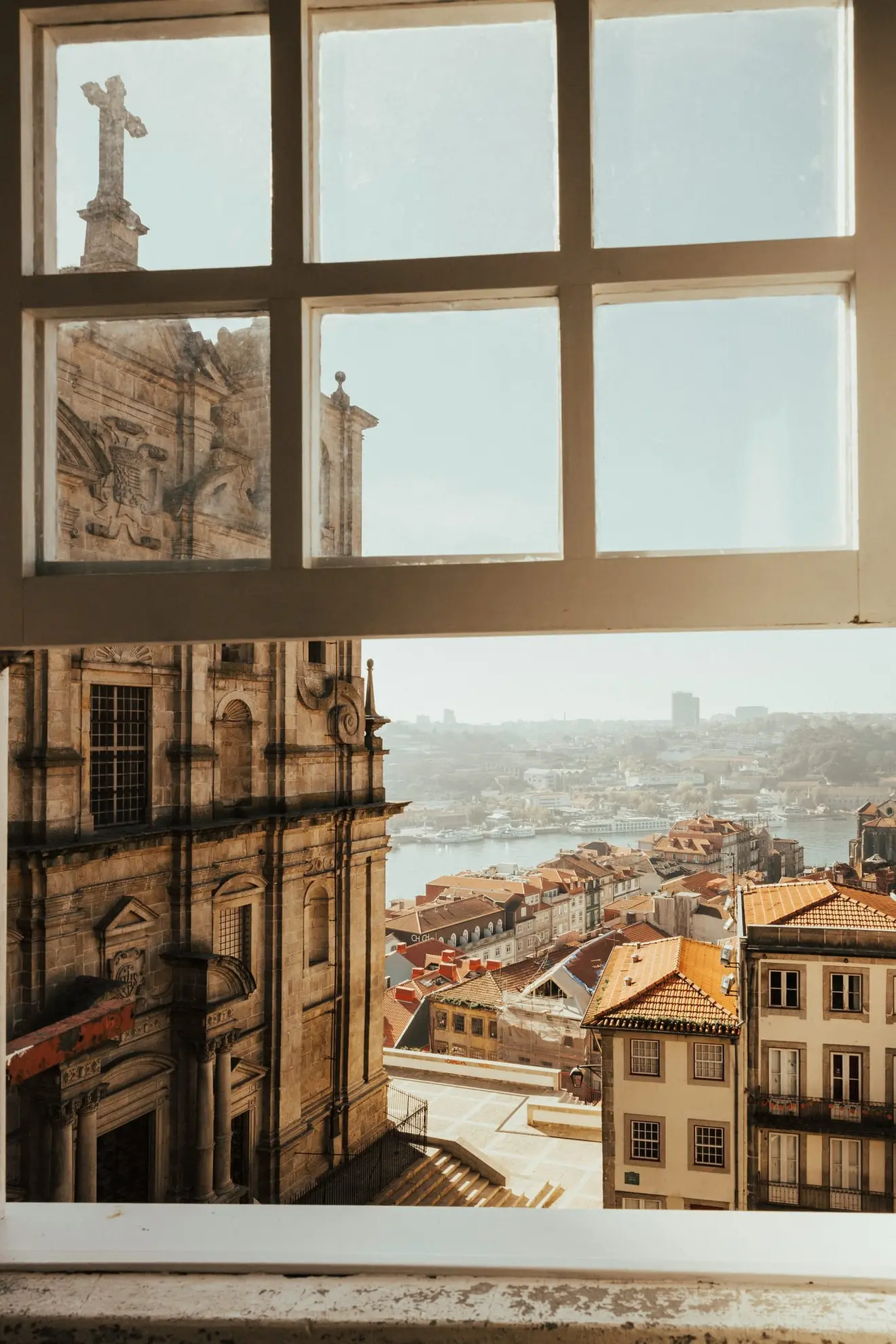 A baroque church facade and the Porto rooftops framed by an old window: the presumption in Article 6.º(10) works the same way, showing lusophone applicants the language half of alínea c) and leaving culture, history and national symbols outside the frame