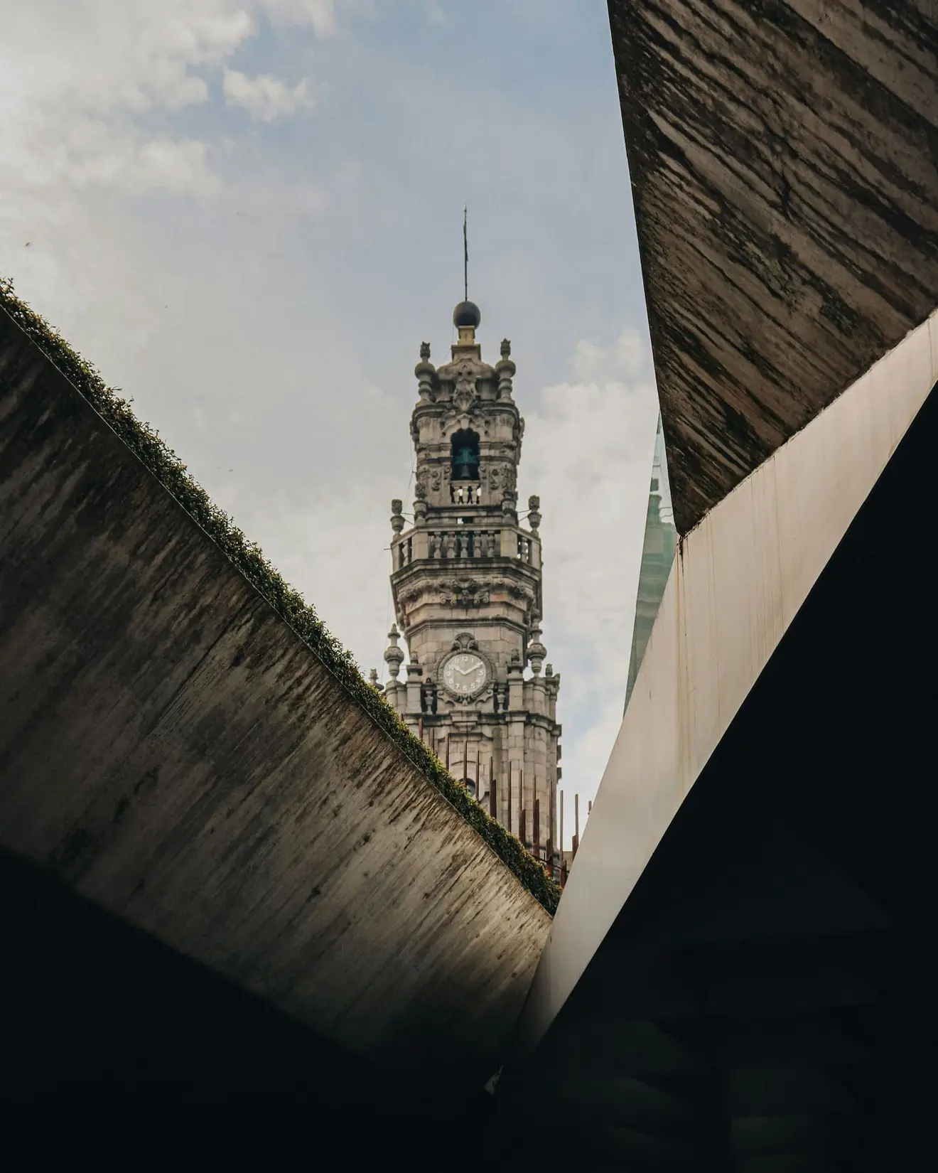 The Torre dos Clérigos framed between modern concrete in Porto. The D3 route through an employer of record is a narrow but entirely ordinary opening, provided the employment behind it is real