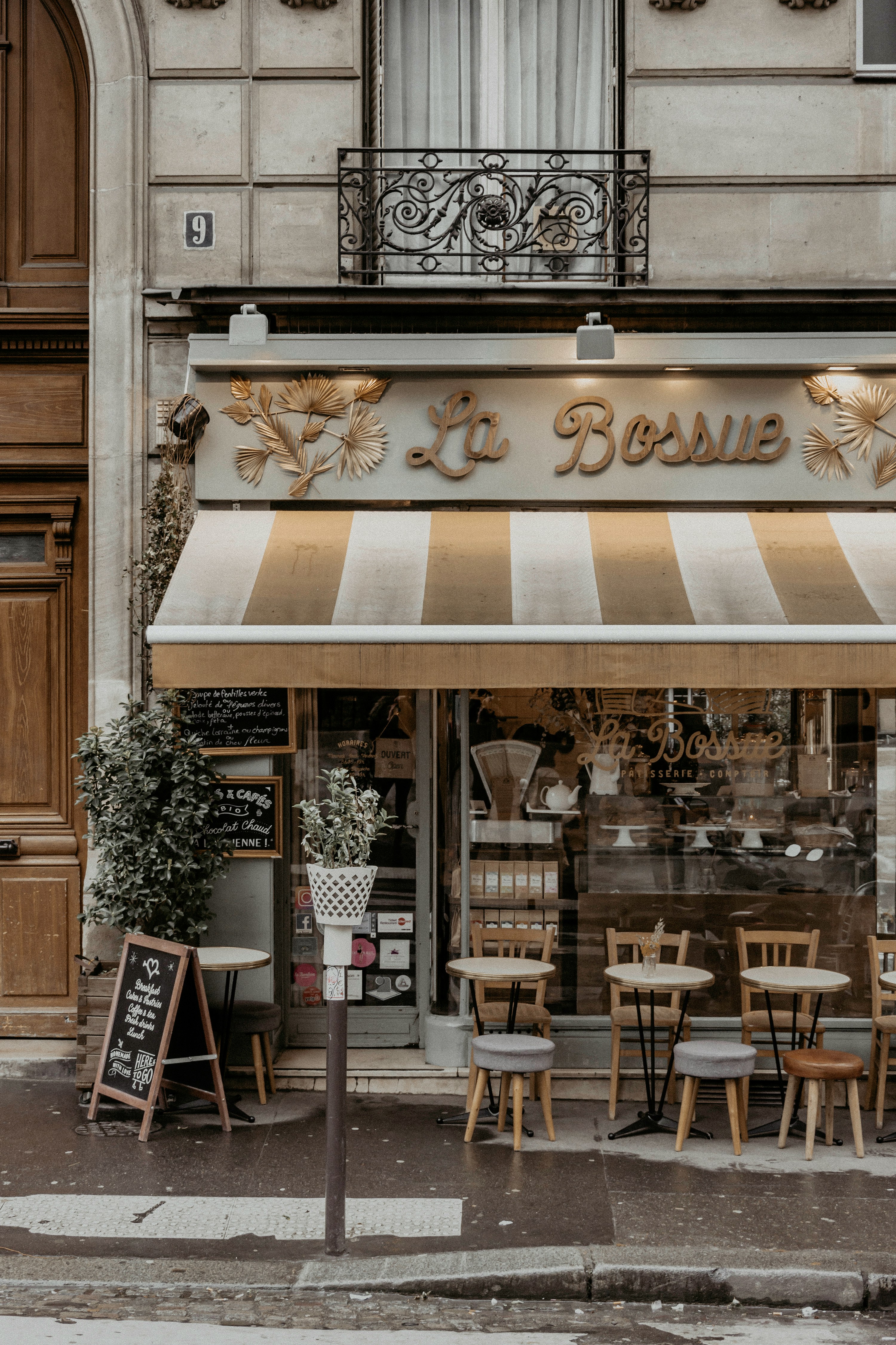 A classic Paris café with striped awning and pavement tables — a new venue in hospitality is a business, but DRIEETS certifies projects that introduce genuine novelty, not new cafés