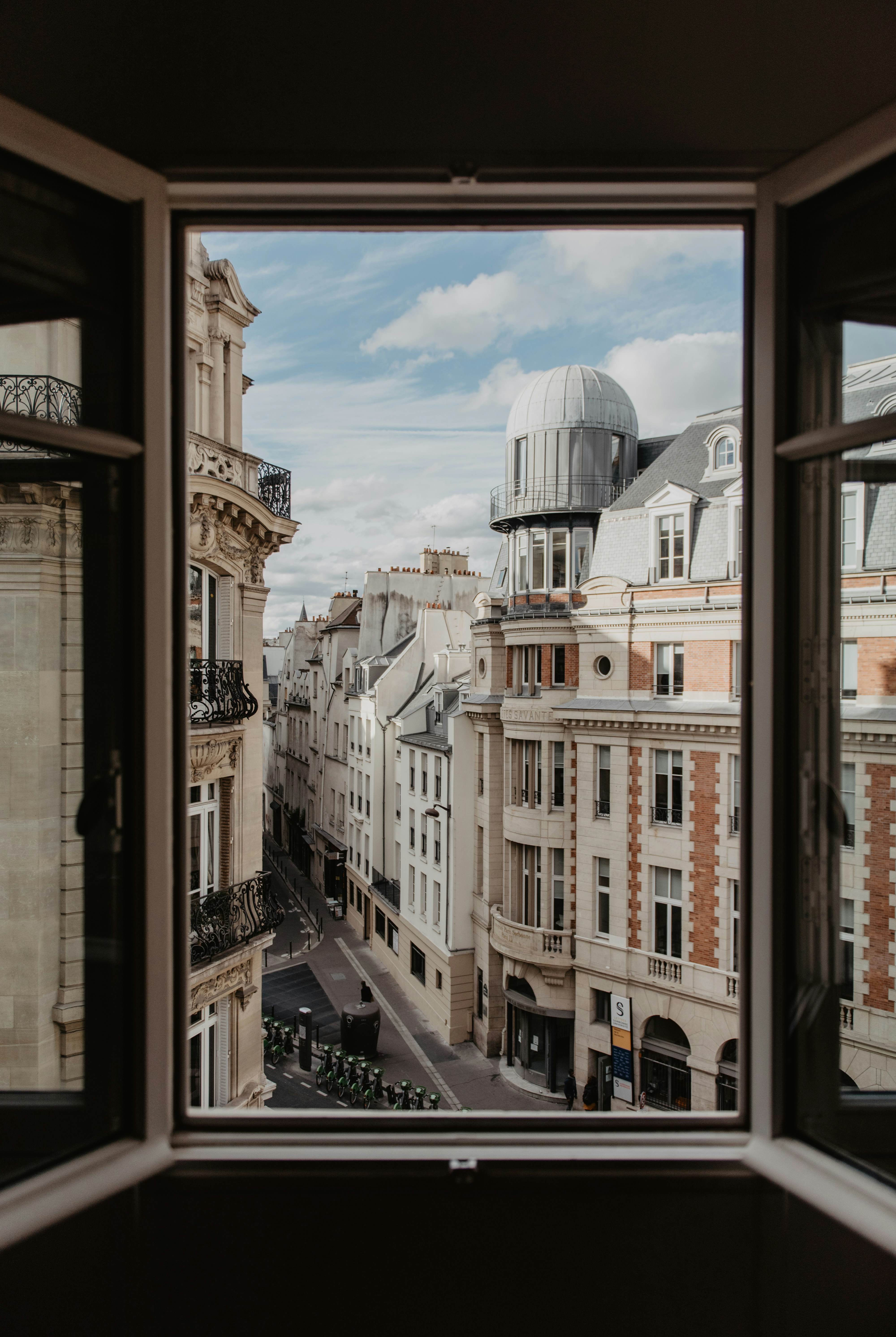 A view over Paris rooftops from an open window — the innovative-project route lets founders base themselves in France before deploying significant capital